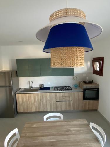 eine Küche mit einem Holztisch und einer blauen Dunstabzugshaube in der Unterkunft Corallo costa dei trabocchi in Torino di Sangro