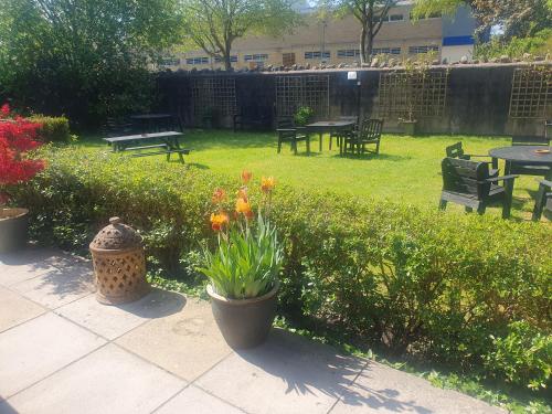 a garden with tables and benches and flowers in it at The Shrubbery Hotel in Shepton Mallet