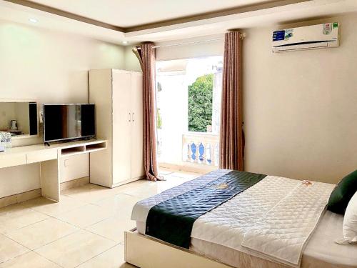 a bedroom with a bed and a tv and a window at Holiday Hotel 2 in An Khê