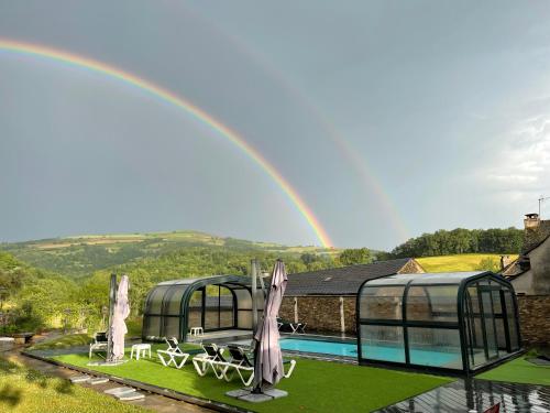 - un arc en ciel au-dessus d'une piscine dans l'établissement Les Magnolias, à Plaisance