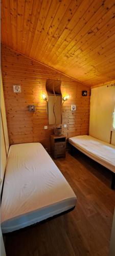 - une chambre avec 2 lits dans une pièce en bois dans l'établissement CHALET 35m2 climatisé 2 chambres vue mer, à Agde