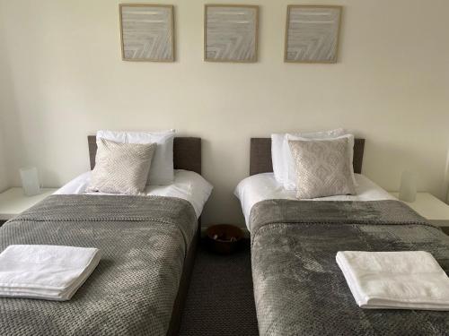 dos camas sentadas una al lado de la otra en una habitación en Entire Home, Long Stay, Contractors, Relocators - LGW, en Horley