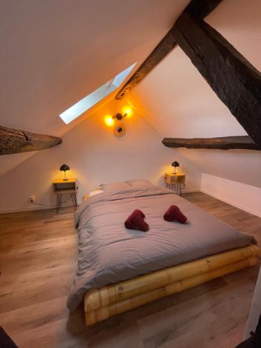 Un dormitorio con una cama con dos zapatillas rojas encima. en Les Cieux de Bourgogne, en Dijon