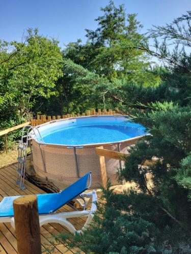 - une piscine sur une terrasse avec une chaise à côté dans l'établissement Cocoon Gîtes 2-4 ou 6 pers avec jacuzzi entre Anduze et Alès, à Carnoulès