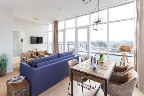ein Wohnzimmer mit einem blauen Sofa und einem Tisch in der Unterkunft Dockside Travemünde in Travemünde