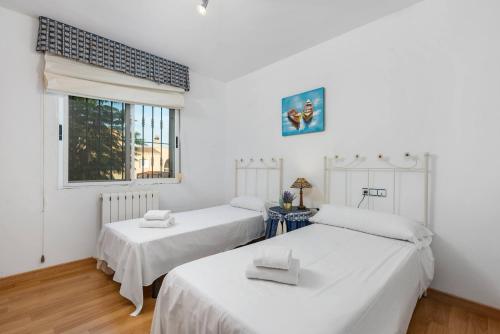 2 camas en una habitación con paredes blancas y ventana en Villa Ricardo - PlusHolidays, en Calpe