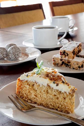 a piece of cake on a white plate with a fork at Paternoster Dunes Boutique Guesthouse in Paternoster