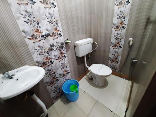 y baño con aseo, lavabo y ducha. en Goroomgo Jagannath Inn Puri Near Sea Beach, en Puri
