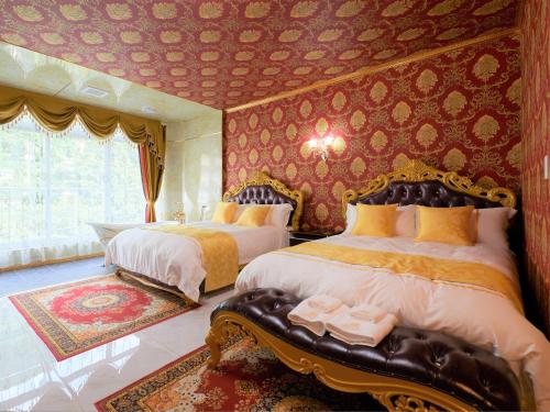 2 camas en una habitación con papel pintado de color rojo en ホテル　ロモサ en Minakami