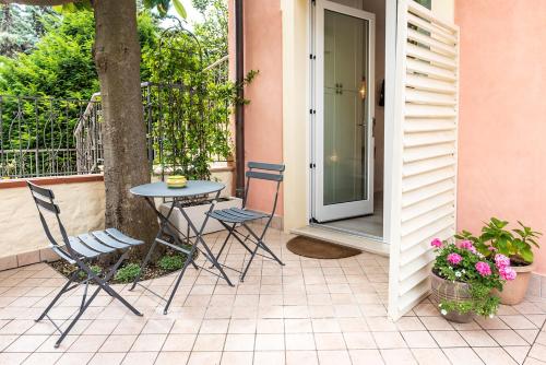 a patio with a table and chairs and a tree at Accanto Alle Mura Rooms & Relax Spa in Sirolo