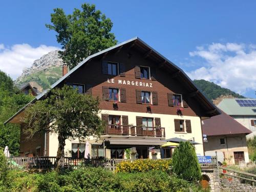 a large house with a gambrel roof at Bar Hotel Restaurant le Margeriaz in Les Déserts