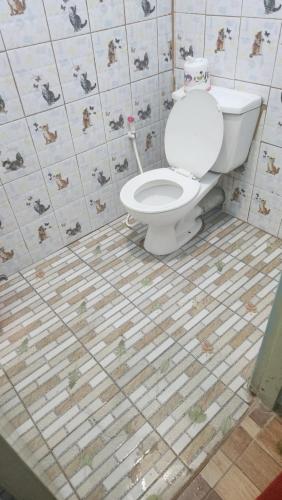 La salle de bains est pourvue de toilettes et de carrelage. dans l'établissement แฟลตลาดหลุมแก้ว2, à Pathum Thani