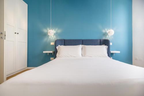 a bedroom with a large bed with a blue wall at Le Suite di Bluemoon in Cagliari