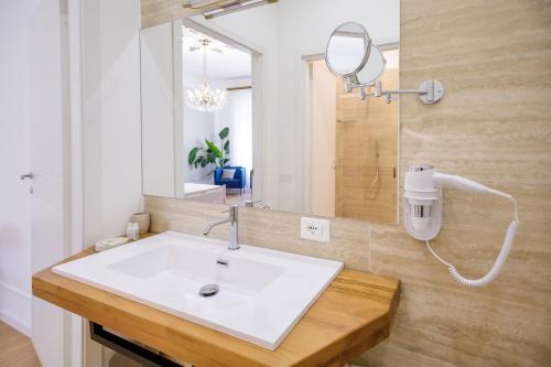 a bathroom with a white sink and a mirror at Le Suite di Bluemoon in Cagliari