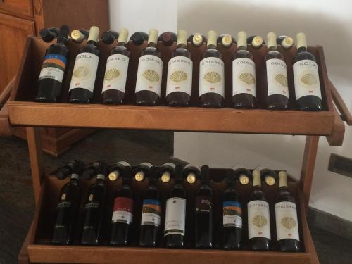 a bunch of wine bottles on a wooden shelf at Hotel Poseidon in Diamante