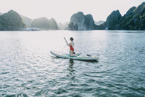 a person on a paddle board in the water at Lan Ha Floating Homestay in Cat Ba