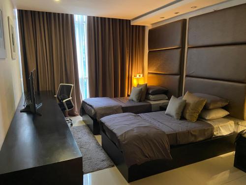 a hotel room with two beds and a television at Platinum 1 in Colombo