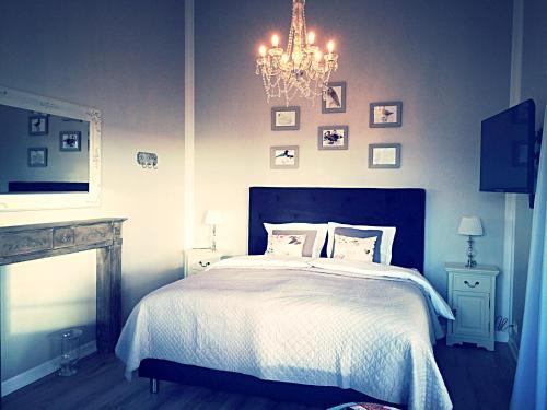 a bedroom with a bed and a chandelier at Mörk Superior Cottages in Hvammstangi