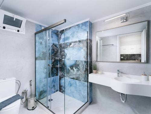 a bathroom with a glass shower and a sink at Dream on in Kalamaki Heraklion