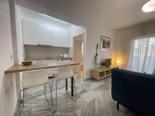 a kitchen with white cabinets and a counter and chairs at Nicosia centre cozy appartment in Nicosia