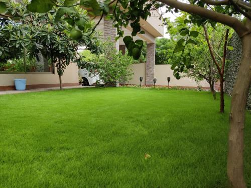 a yard with a green lawn in front of a house at Alpha Guest House in Rawalpindi