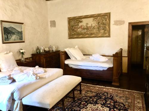 - une chambre avec 2 lits et un banc dans l'établissement Domaine du Très-Haut - Château de Montanges, à Montanges