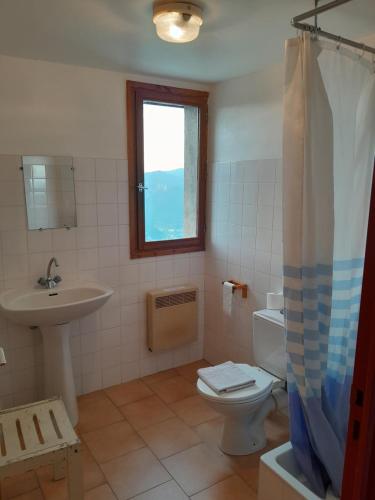 a bathroom with a sink and a toilet and a window at Refuge de Roncharel in Annot