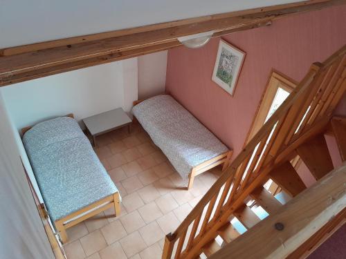 an attic room with two beds and a staircase at Refuge de Roncharel in Annot