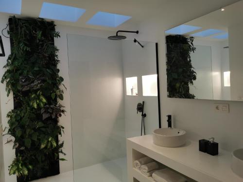 baño con pared verde con lavabo y espejo en Villa Tagoror, en Tiagua