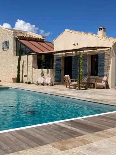 une maison avec une piscine devant une maison dans l'établissement Mas de charme avec piscine au coeur des Alpilles, à Eygalières