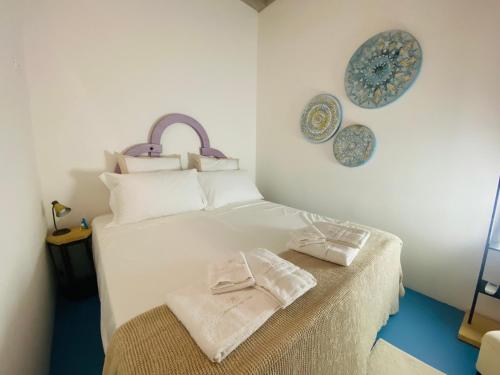 ein Schlafzimmer mit einem weißen Bett und blauen Platten an der Wand in der Unterkunft Dimora del Sole Luxury and charm apartment in Otranto