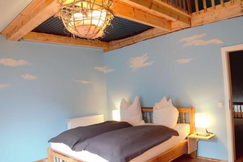 a bedroom with a bed with a ceiling with clouds at Biberbau in Reinsfeld