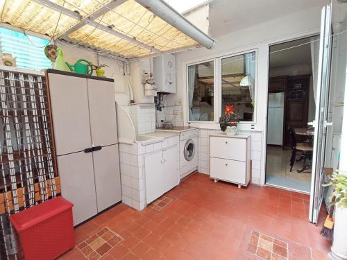 una cucina con armadi bianchi e una lavatrice/asciugatrice di Cuntis Village L&H a Ferrol
