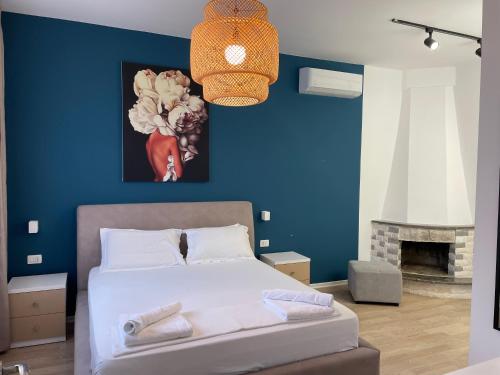 - une chambre avec un lit et un mur bleu dans l'établissement PINE HOUSE 2023, à Vlorë