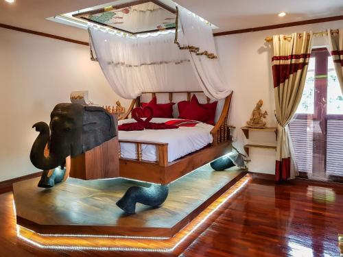 ein Schlafzimmer mit einem Bett mit einem Elefanten auf dem Boden in der Unterkunft Olivier Boutique in Chiang Mai