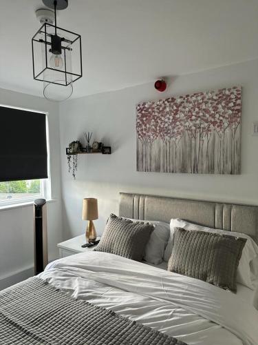 a bedroom with a bed and a painting on the wall at Isabella Rooms in Hockley