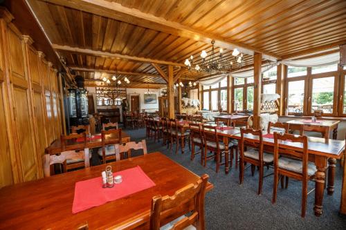a dining room with wooden tables and chairs at Hotel Jelinek in Špindlerův Mlýn