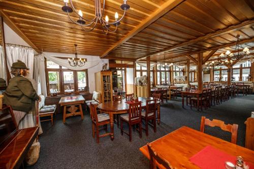 a dining room with wooden tables and wooden chairs at Hotel Jelinek in Špindlerův Mlýn