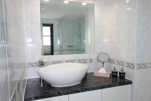 bagno con grande lavandino bianco e specchio di HAPPY-HOMES - Up to 5 - Küche - W-LAN - Netflix - Honig - Terrasse ad Altenstadt