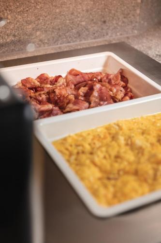 a plate of food with bacon and eggs on a counter at Boutique Hotel 'Hof ter Duinen' in Oostduinkerke