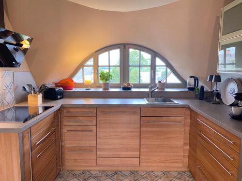 a kitchen with wooden cabinets and an arched window at Ferienhaus Mü in Rankwitz