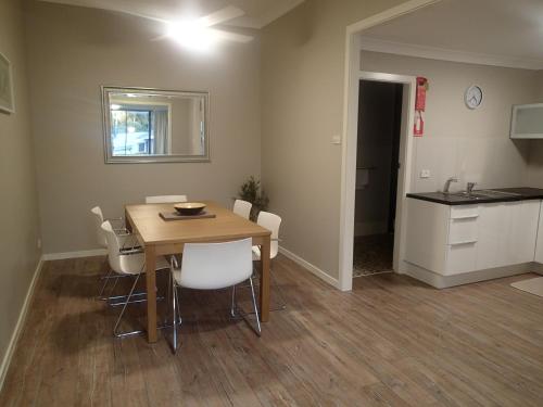 a dining room with a table and white chairs at Dungowan Holiday Accommodation in Erowal Bay