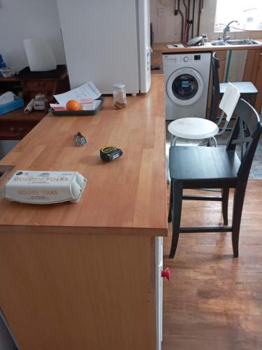 a kitchen counter with a washing machine and a chair at Morgan Ease in Manchester