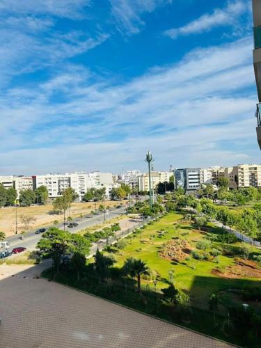 un parc au milieu d'une ville avec des bâtiments dans l'établissement Vue sur le Parc Prestigia Fès, à Fès