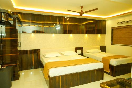 sypialnia z 2 łóżkami i wentylatorem sufitowym w obiekcie S S RESIDENCY w mieście Padubidri