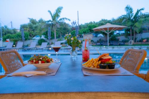 a table with two plates of food and a drink at Remezzo Studios & Apartments in Amoudi