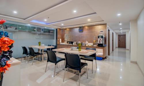 a kitchen and dining room with two tables and chairs at Treebo MVP Grand in Visakhapatnam