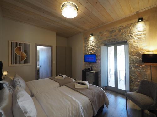 a bedroom with a large bed and a stone wall at Terra Di Pietra Exclusive Suites & Apartments in Areopolis