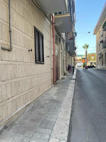 an empty street next to a building with a window at L'angolo Zen in Margherita di Savoia