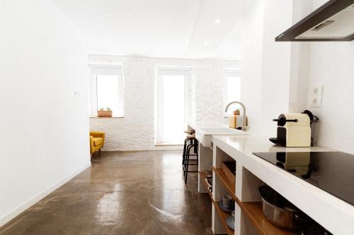 a kitchen with white walls and a counter top at Apt. con balcón y vistas a la playa Alguer in L'Ametlla de Mar